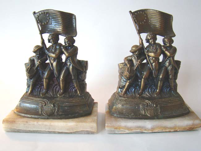 A pair of "Spirit of 1776" or "Yankee Doodle Dandy" Revolutionary War themed bookends on a marble base